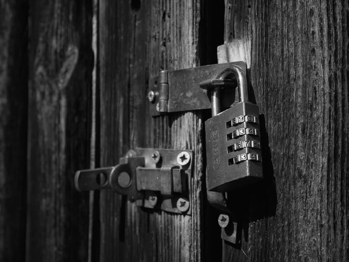 Padlock on an old wooden door in black and white