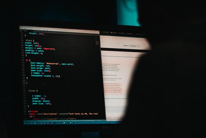 Laptop with code on screen in a dark room