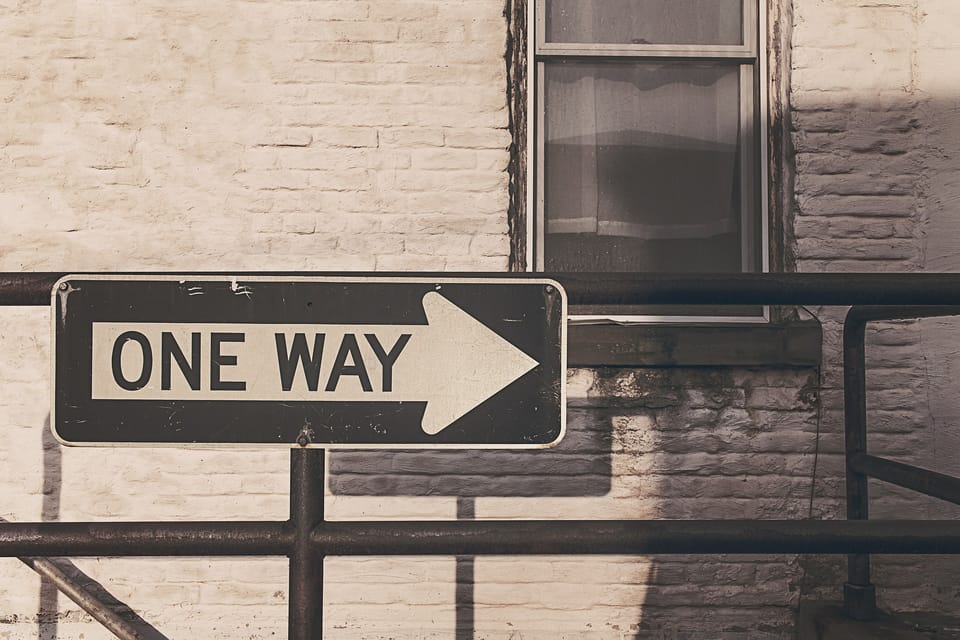 One-way street sign on a brick wall